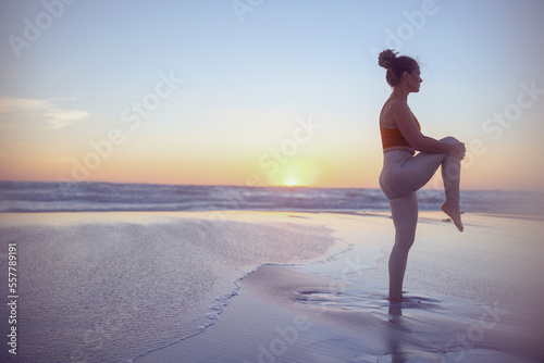 Fototapeta Naklejka Na Ścianę i Meble -  healthy woman jogger at beach at sundown stretching