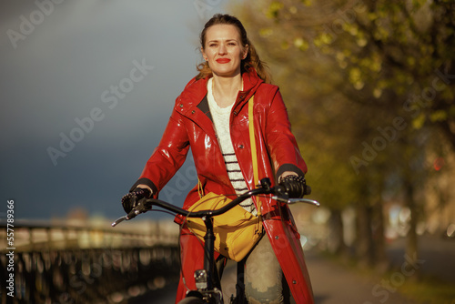 smiling elegant woman outdoors on city street riding bicycle