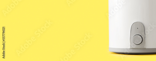 Modern electric boiler on yellow background with space for text