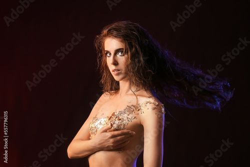Naked young woman with gold...