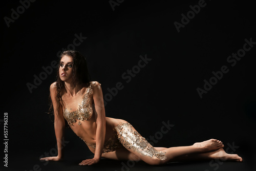 Naked young woman with gold...
