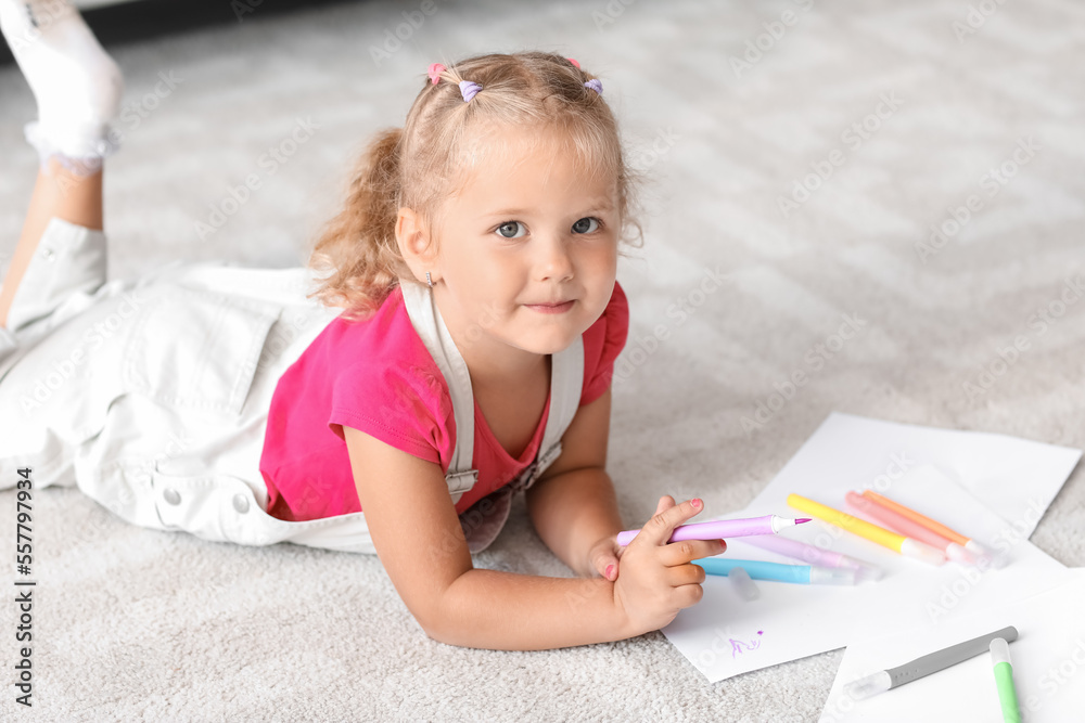 Cute little girl drawing with felt-tip pen on floor at home Cute little girl drawing with felt-tip pen on floor at home