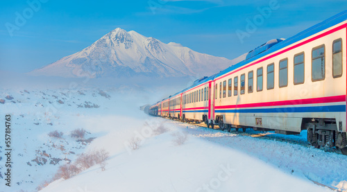 Red diesel train in motion at the snow covered railway platform - The train connecting Ankara to Kars - Passenger train going through 