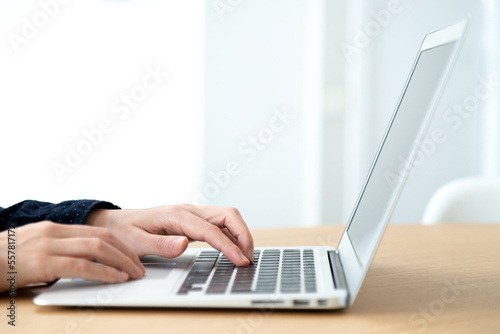  Close up of hands typing laptop. Selective focus on hands. Copy space.