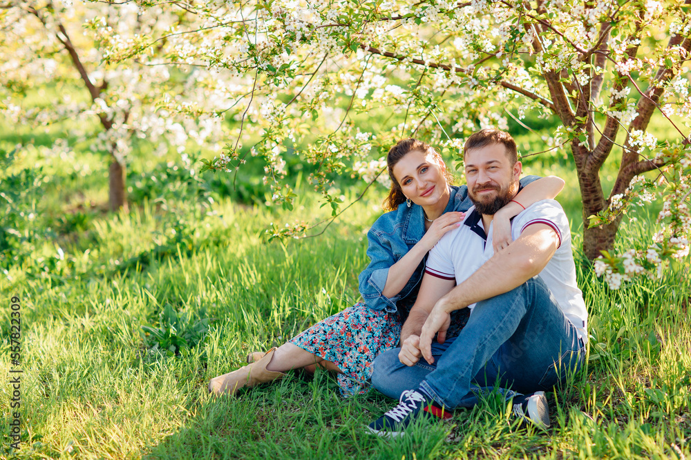 Fototapeta premium a man and a woman on a lawn in a blooming spring garden. 