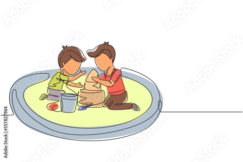 Single continuous line drawing two little boys build sandcastle together. Children sitting on sandbox and playing with sand castle. Brothers or friends having fun. One line draw graphic design vector