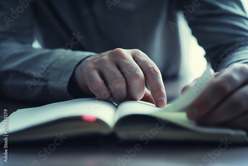 Read book. A man sits and reads religion literature. Textbooks to study.