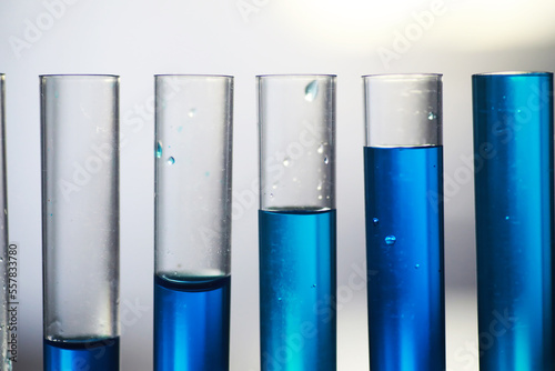 Test tube with blue liquid on the laboratory table. Examination of liquid under a microscope.