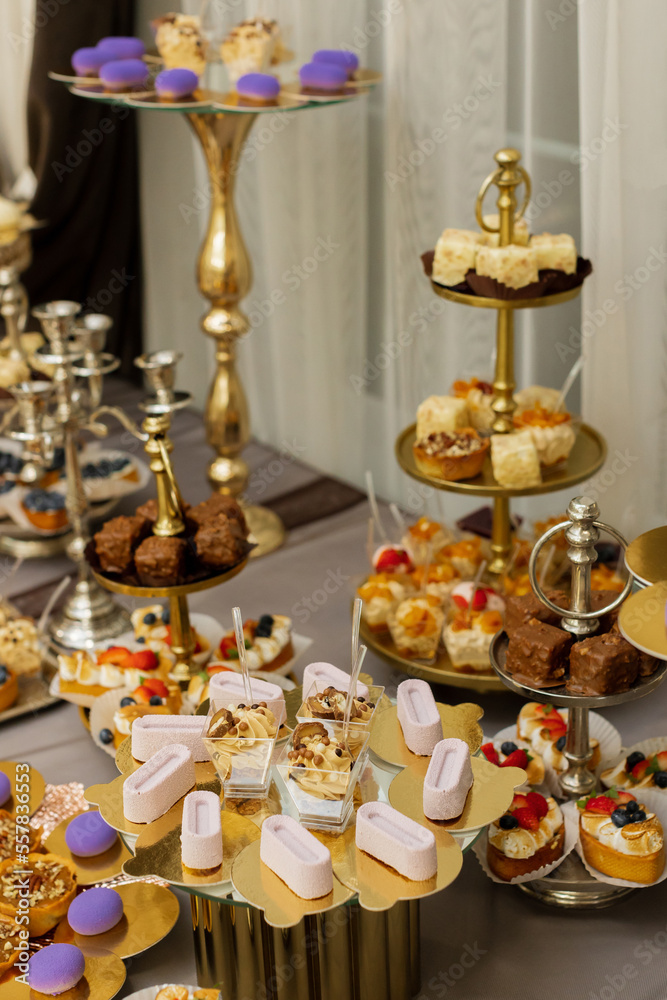 Table with cakes, sweets, candy, buffet. Dessert table for a party goodies for the wedding banquet area. Close up candy bar. Decorated delicious.