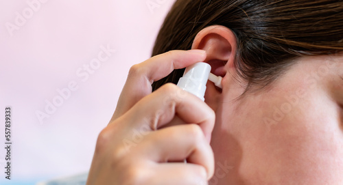 Bild auf Leinwand Using a spray to clean the ears, clogged by the secretion of the ear, the cork