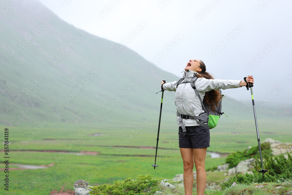 Excited hiker celebrating her healthy life in nature