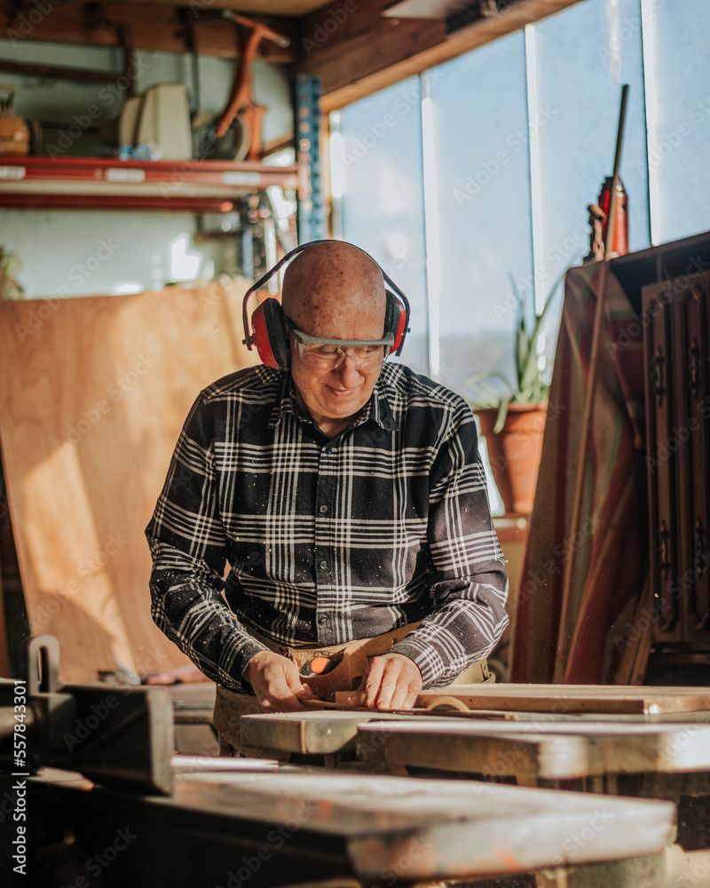 Carpenter cutting wood in workshop Carpenter cutting wood in workshop
