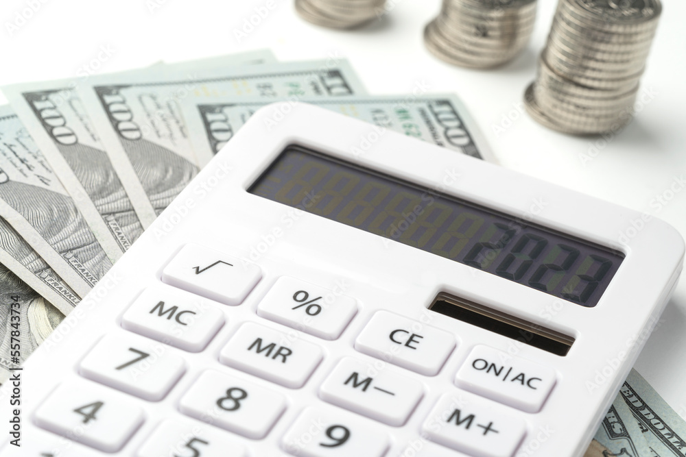 A white calculator with 2023 on the screen. A concept for recording income, expenses and controlling finances. A white calculator with 2023 on the screen. A concept for recording income, expenses and controlling finances.