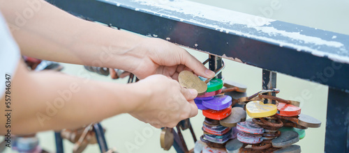 Woman Traveler hand lock key during travel in Da Nang. Tourist sightseeing at love lock bridge. Landmark and popular. Vietnam and Southeast Asia travel concept