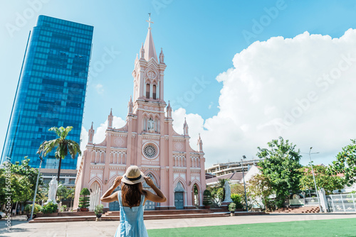 Woman Traveler with blue dress visiting in Da Nang city. Tourist sightseeing the Da Nang Cathedral church. Landmark and popular for tourist attraction. Vietnam and Southeast Asia travel concept photo