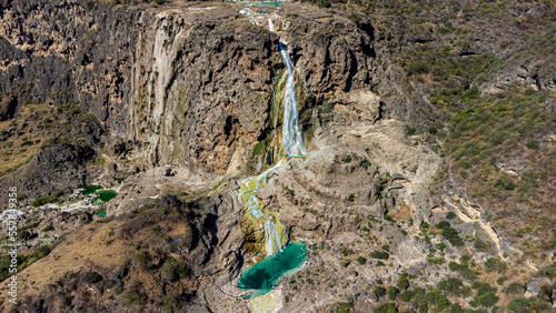 Oman, Dhofar, Salalah, Aerial panorama of Wadi Darbat waterfall splashing down rough cliff photo