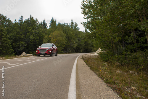 2023 Route. Road in the forest ith red car. © HsnStone