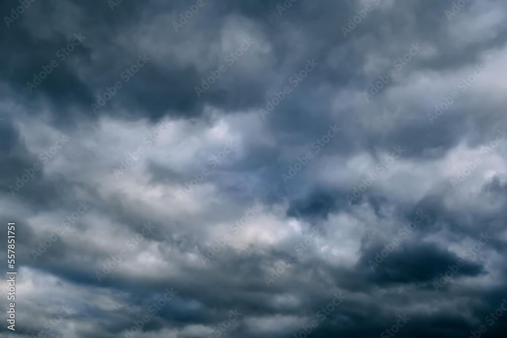 A dark blue cloudy sky. Cumulus clouds. Nature background. Bad weather forecast. Before a thunderstorm, hurricane or storm. The power and strength of nature. Air element. Wallpaper. Moving ciclone