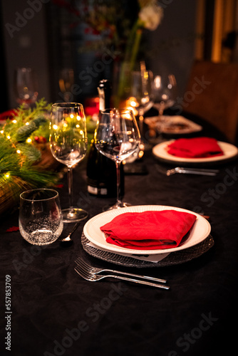 Dinner setting. Glassware ready on a festively dressed dinner table. Red napkins, dark tablecloth, silverware.