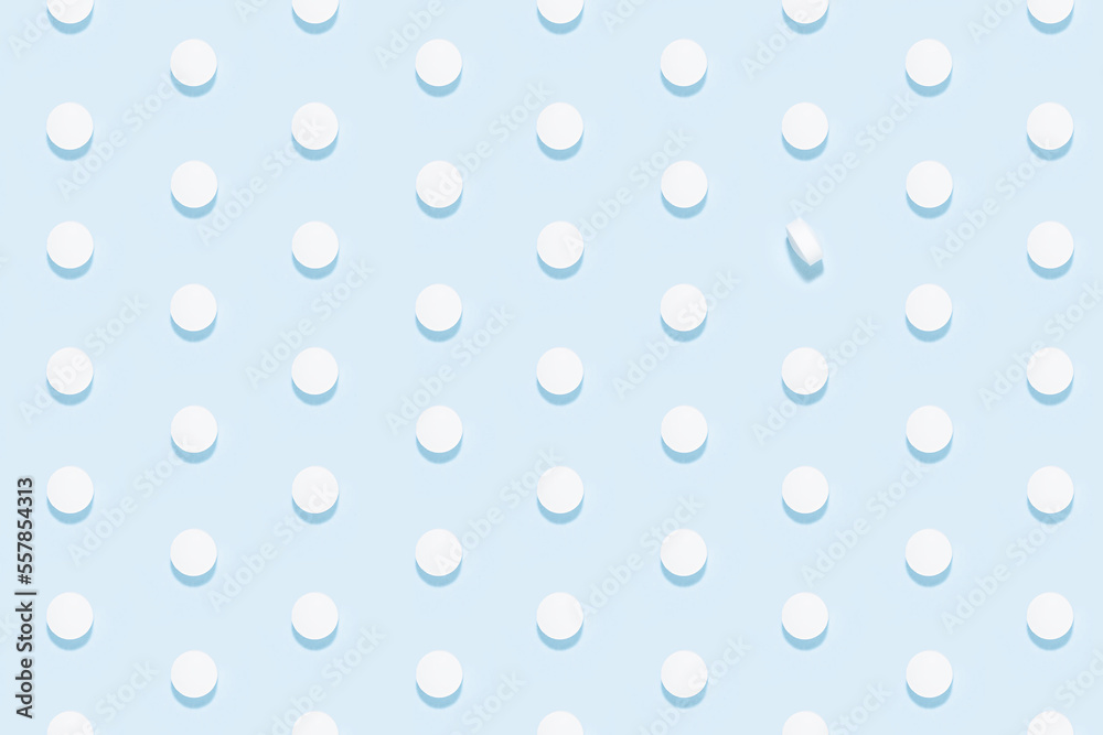 White pills as seamless pattern on soft light blue background in hard light with shadow, top view. Medical and treatment modern minimal background - remedies for prevent and teraphy disease, sickness.