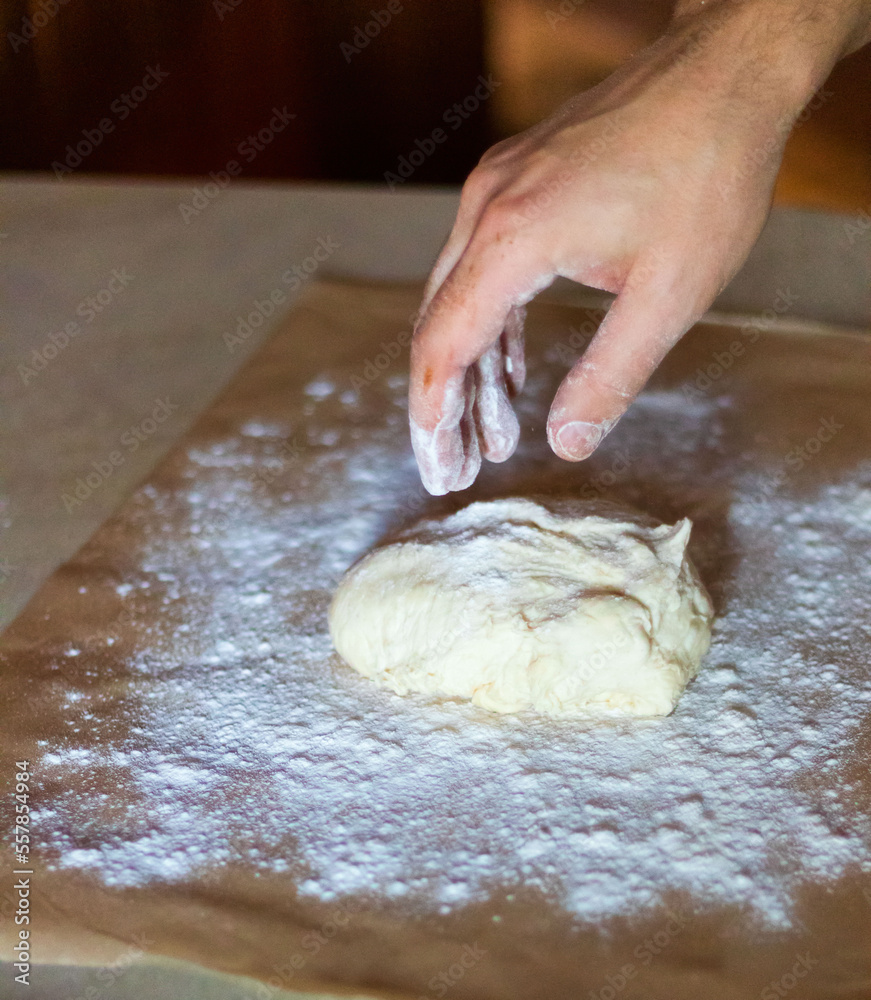 Cooking dough for pizza. The cook rolls out the dough and sips the flour Cooking dough for pizza. The cook rolls out the dough and sips the flour