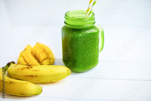 Side view of smoothie with banana, mango, spinach on wooden table. Healthy food. Copy Space 