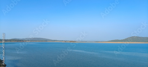 River with clear blue sky and green forest background, blue lake panoramic view