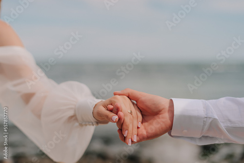 Couple's hand in front of the black sea