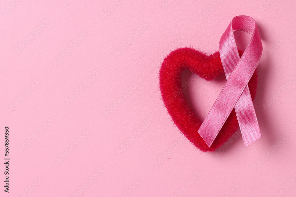Pink ribbon breast cancer with heart shape on pink background with copy space. Breast Cancer Awareness. 