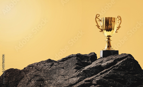 Golden trophy cup on the top of the rock mountain. Business goal and success concept. Champion reward. Prize to winner. Challenge for victory.