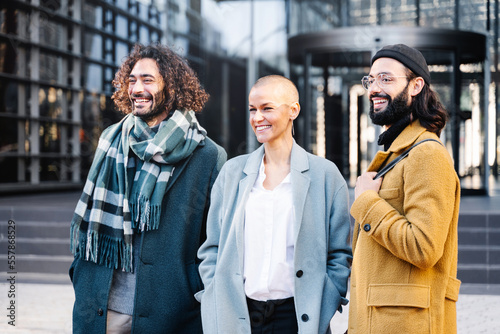 Woman boss with shaved hair and Happy positive coworkers of modern creative company smiling outside the company office in winter