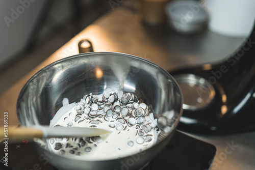 Closeup shot of melting chocolate chips with heavy cream over boiling water. Blurred background. High quality photo photo