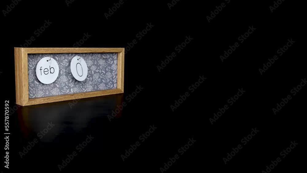 A wooden calendar block showing the date February 5th with a mans hand putting on and taking off the metal discs with the date and month on them, filmed in 4k quality A wooden calendar block showing the date February 5th with a mans hand putting on and taking off the metal discs with the date and month on them, filmed in 4k quality