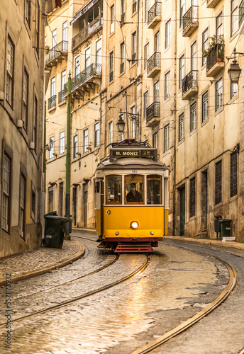 The famous, old, yellow trams travelling around the streets of Lisbon, Portugal