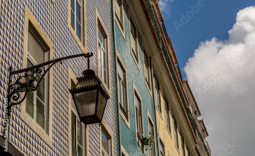 The old, metal, street lamps mounted on colorful tiled buildings in Lisbon, Portugal 