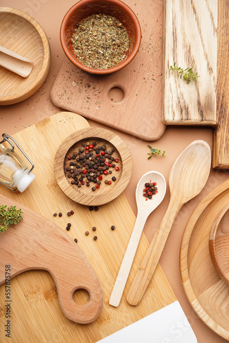 Wooden cooking utensils with spices on beige background