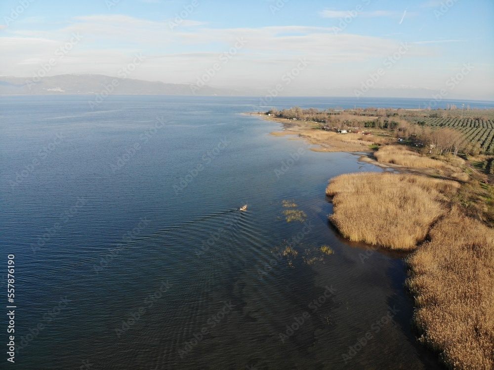 Iznik lake and a boat are moving through the reeds