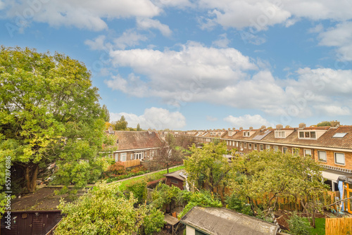 a residential area with houses and trees in the fore, taken from an aerial view point on a sunny day photo