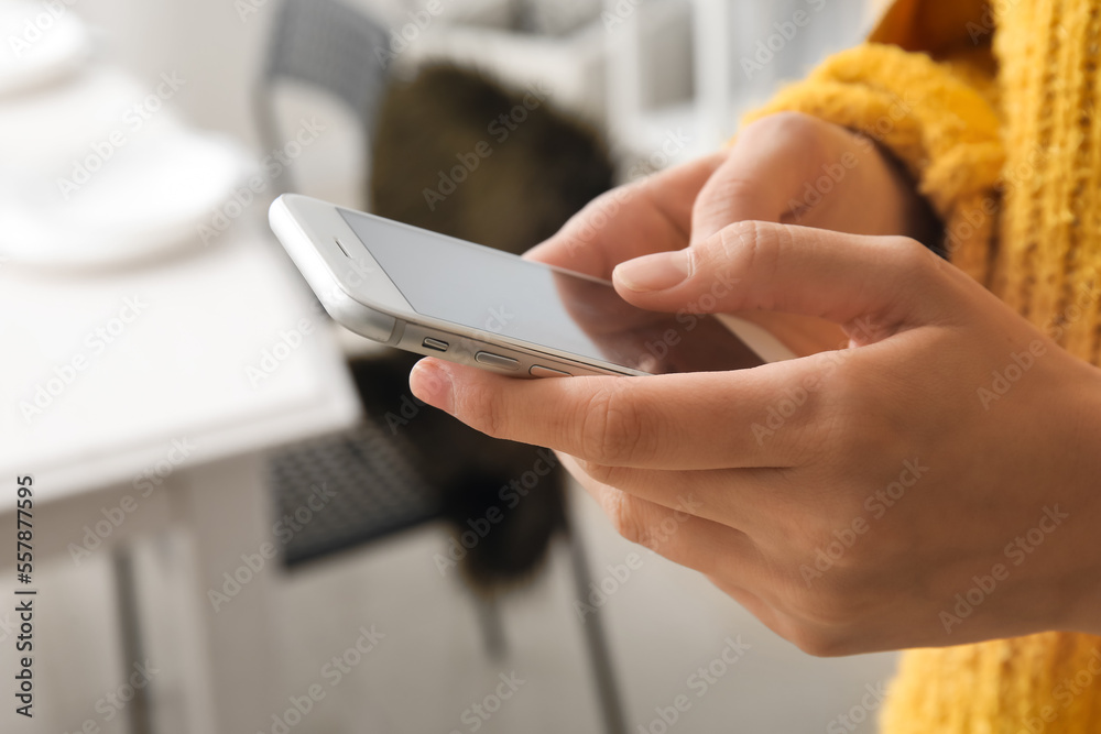Young woman using smartphone at home, closeup