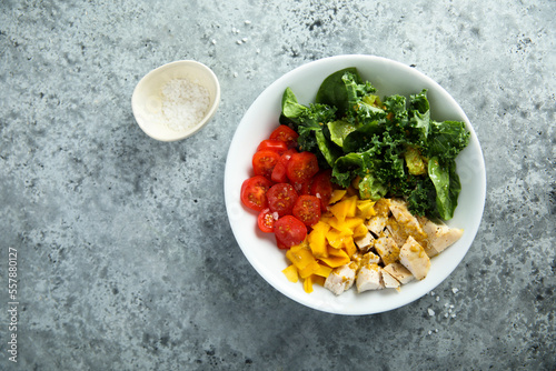 Homemade chicken bowl with mango and kale