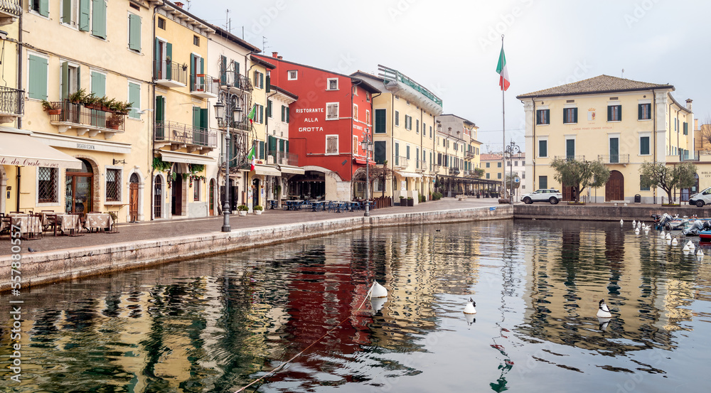 Old harbor of the small and picturesque town of Lazise on Lake Garda in the winter season. Lazise, Verona province, northern Italy - January 21, 2022