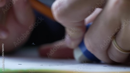 Closeup hand erasing mistake on paper. Macro extreme close up of person using eraser with pencil
