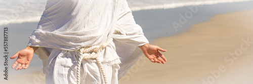 Obraz na płótnie Christ-like man in white robe with open arms, closeup body shot next to sea w salonie