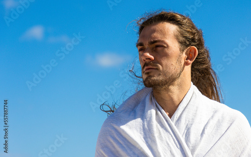 Obraz na płótnie Handsome man who looks like Jesus Christ head shot against blue sky w salonie