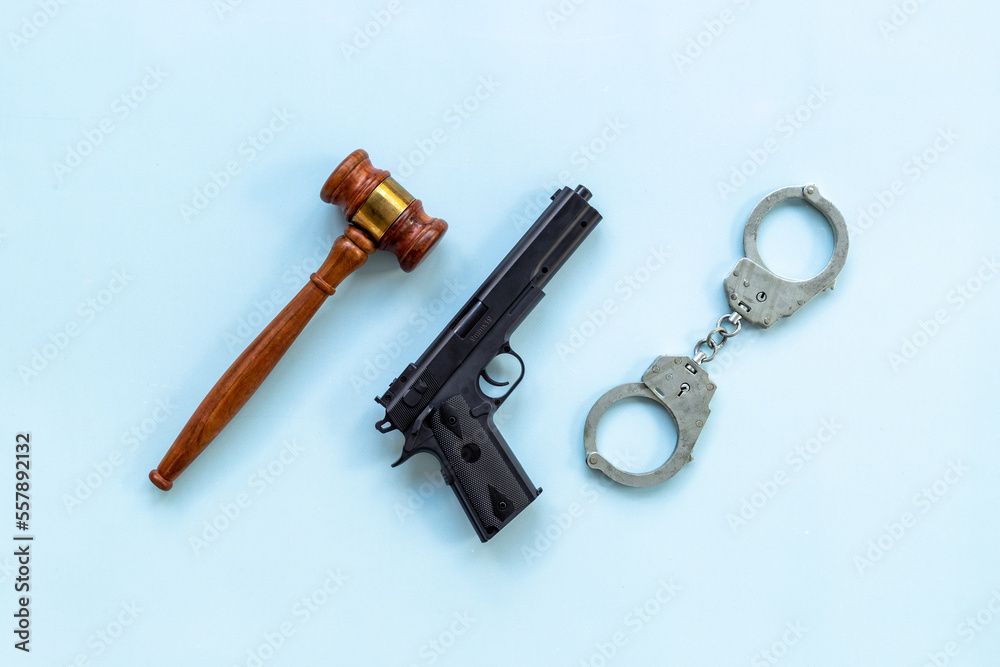 Hand gun weapon with handcuffs. Arrest of a criminal concept Hand gun weapon with handcuffs. Arrest of a criminal concept