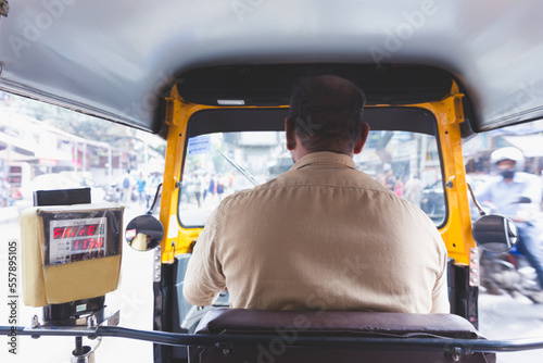 Mumbai, India, 10 january 2020. Sitting in the back of an indian tuk tuk, facing the indian driver's back and taxameter with fare while touring the busy streets of Mumbai. International tourism.