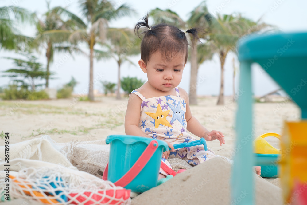 Cute baby girl sitting and playing on the beach toys on tropical beach. Travel vacation on holiday. Happy life on summer time. Cute baby girl sitting and playing on the beach toys on tropical beach. Travel vacation on holiday. Happy life on summer time.