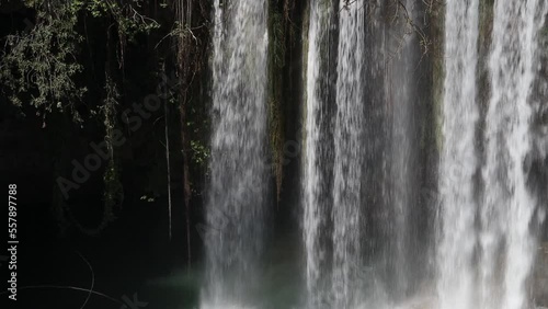 A wall of water falls from a natire waterfall. photo