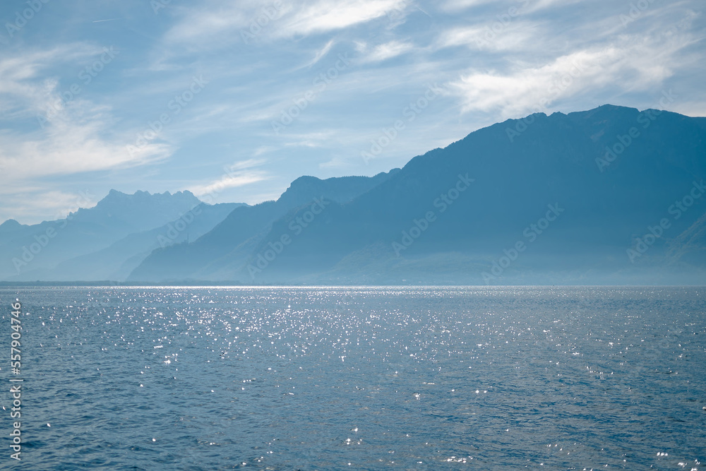 seascape with light reflection on the surface with mountain and blue sky as background