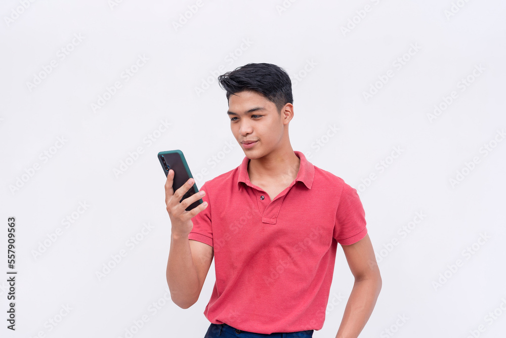 A young man reading messages on his phone. Chatting on his mobile device. Isolated on a white background. A young man reading messages on his phone. Chatting on his mobile device. Isolated on a white background.